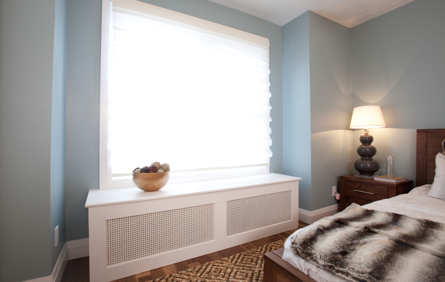 Contemporary bedroom with fur throw and sleek radiator cover