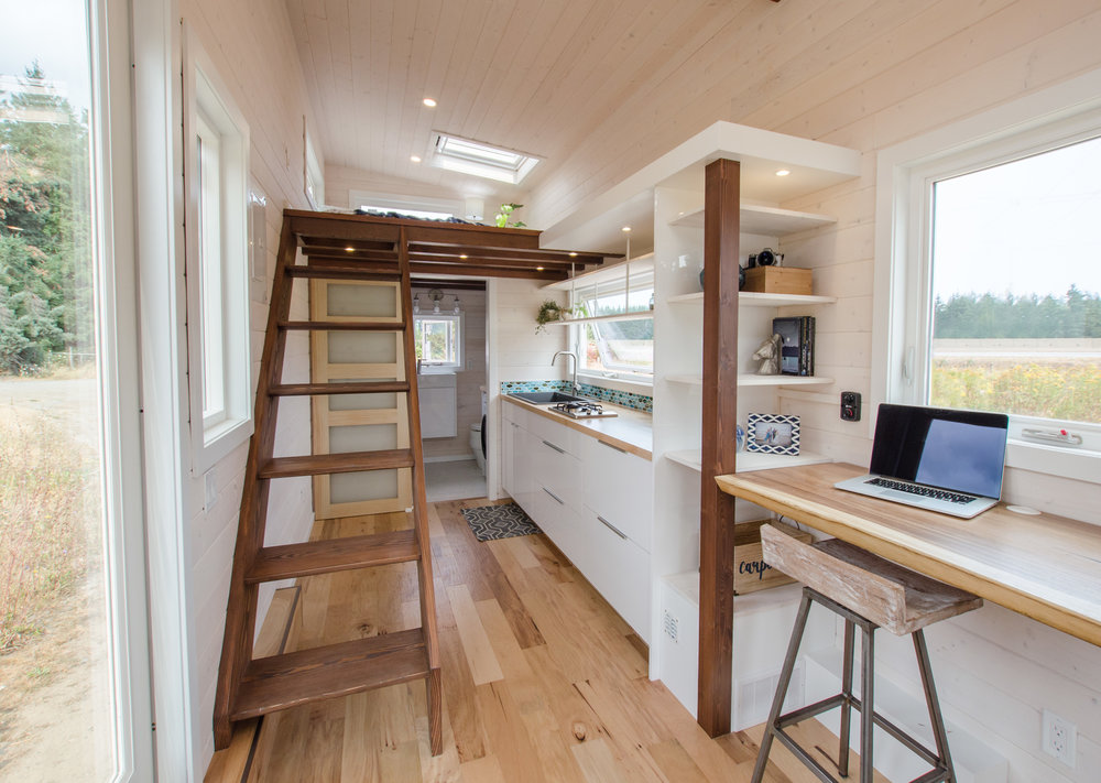 white tiny home interior with field outside window