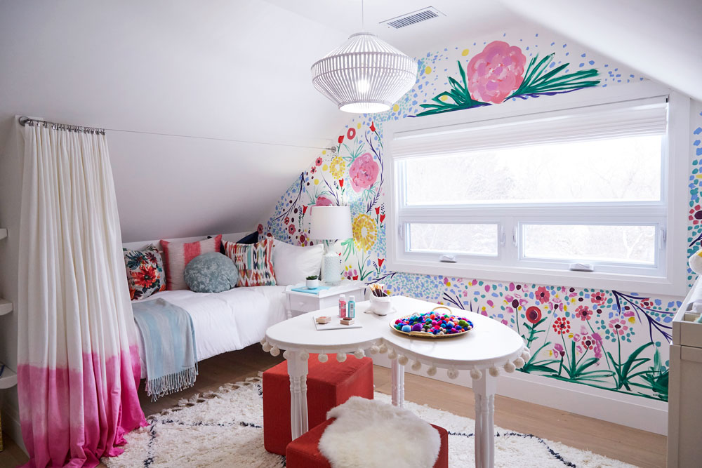 A bright kid's room with a painted mural on one wall