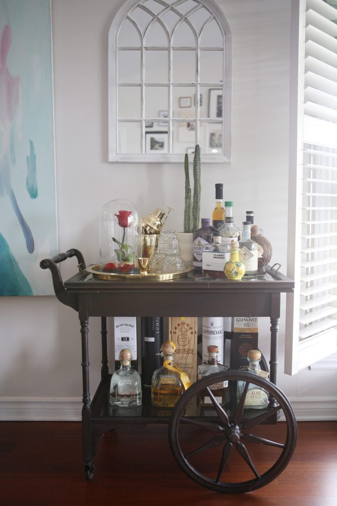 bar cart with bottles and cactus