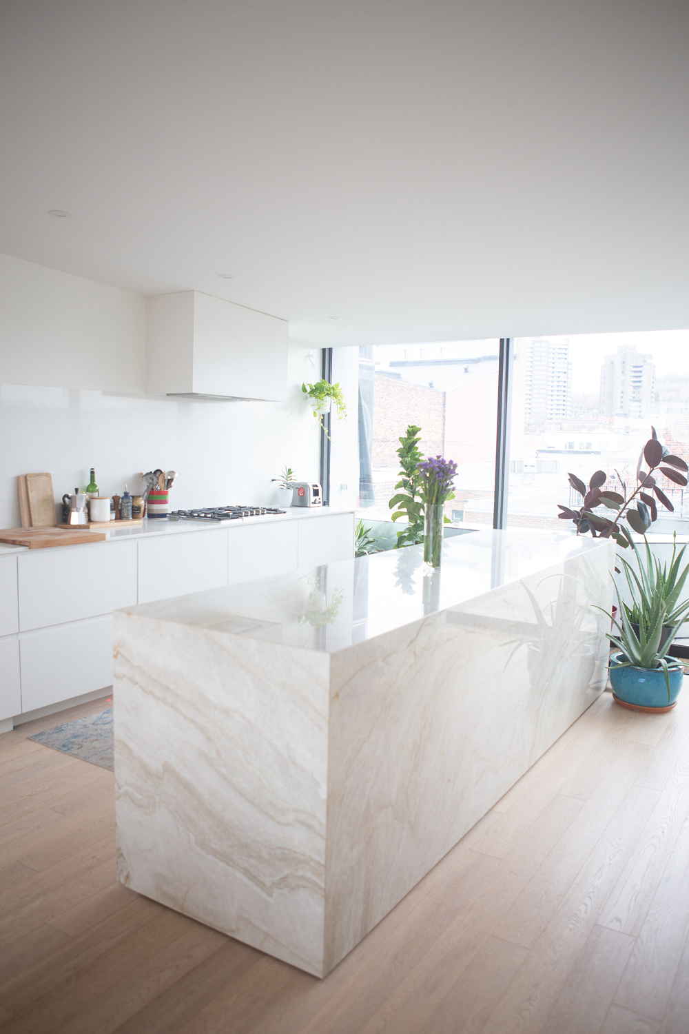 solid marble island in white kitchen with plants