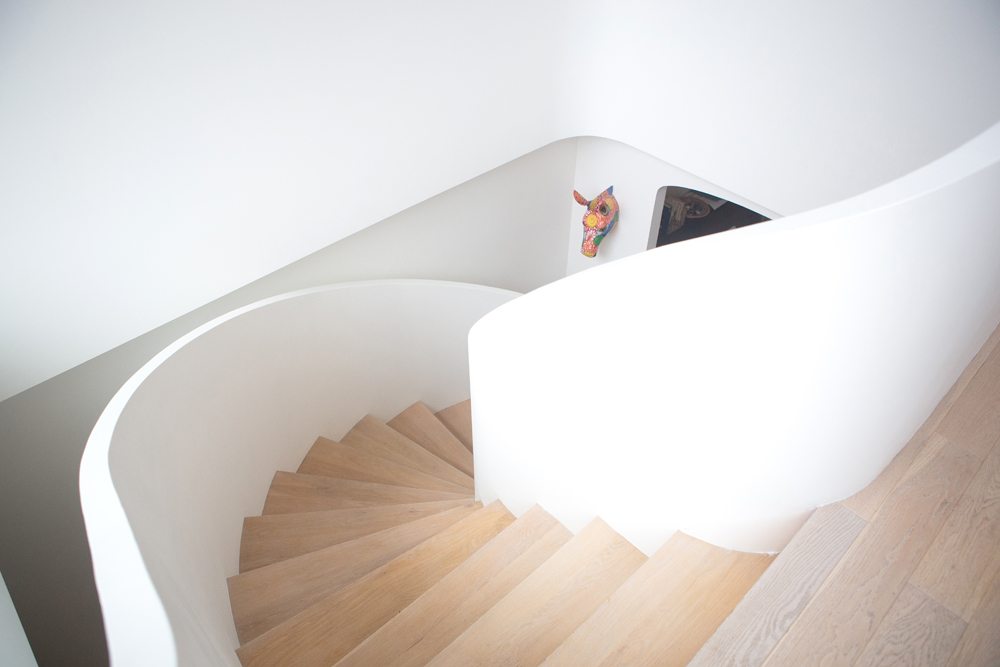curved wood stairs with white walls and colourful horse head
