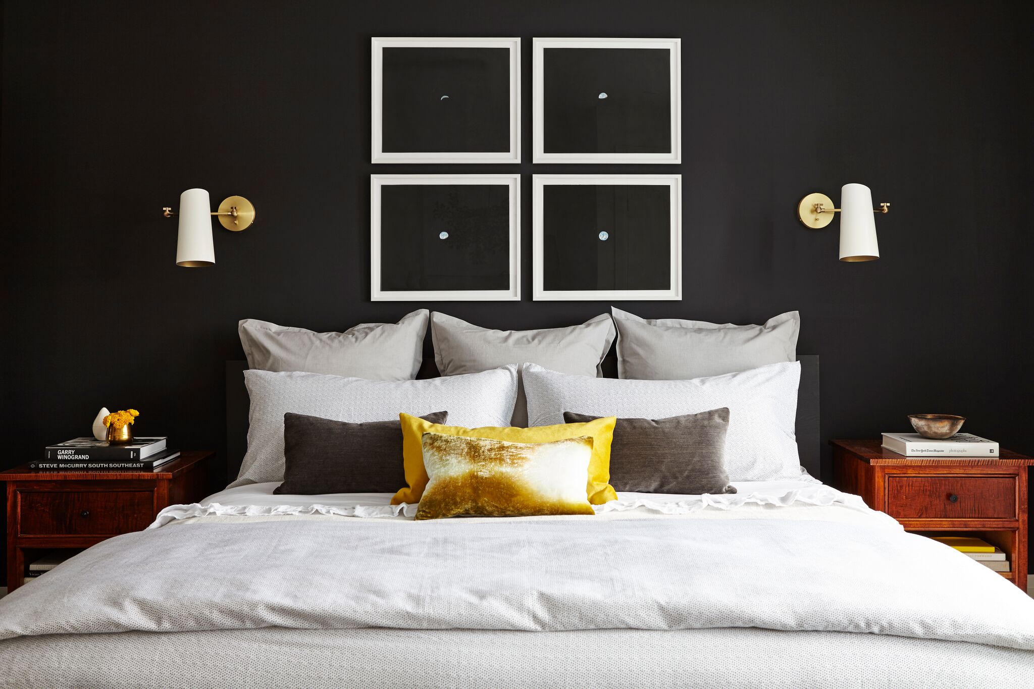 bedroom facing black focal wall with four black prints with white dot in centre