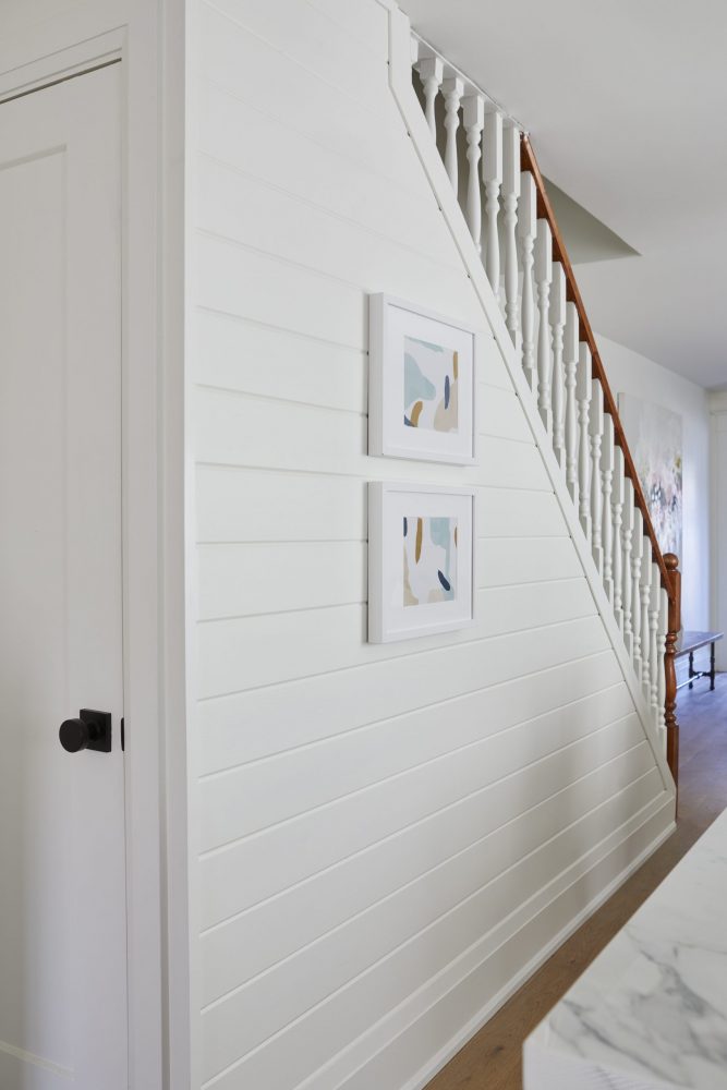 A renovated staircase wall covered in painted shiplap