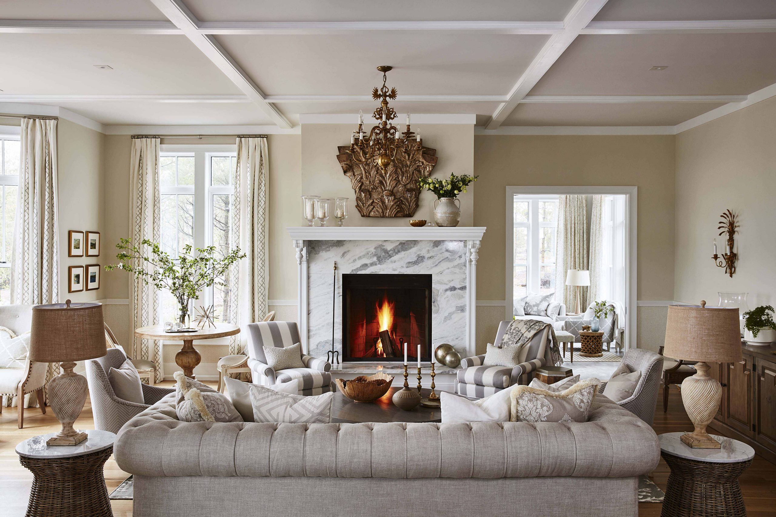 A show-stopping marble fireplace, neutral furniture and lots of textured fabrics create the luxurious look of this living room.