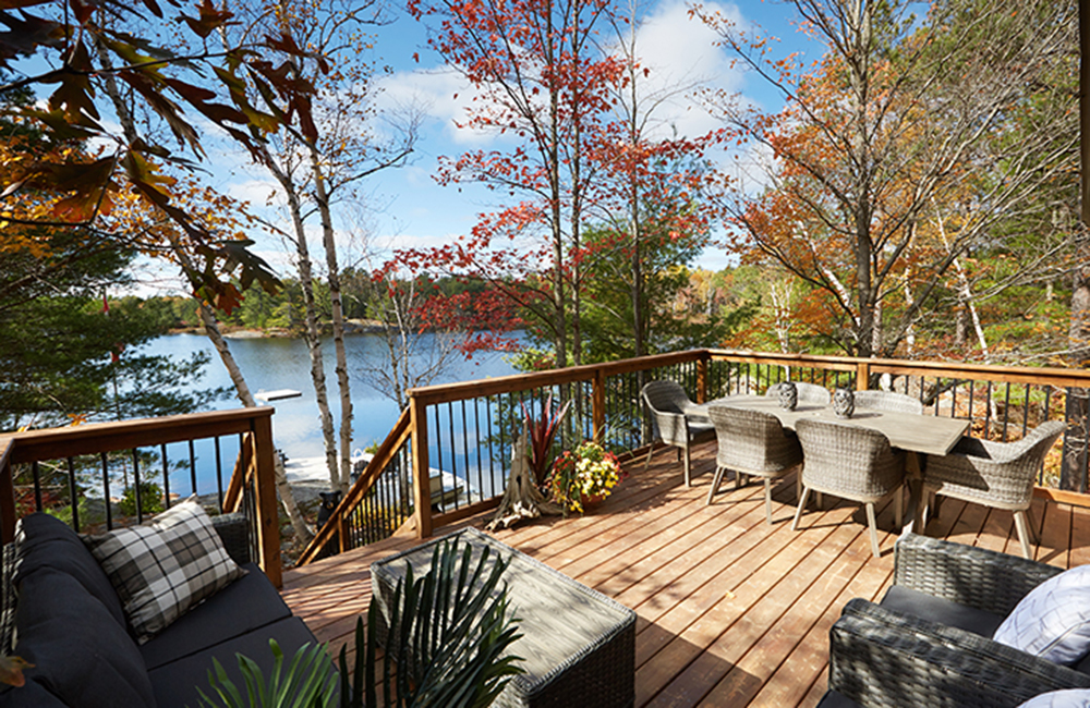 A cottage deck overlooking a peaceful lake.