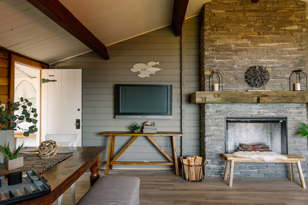 rustic living room with grey walls and stone fire place