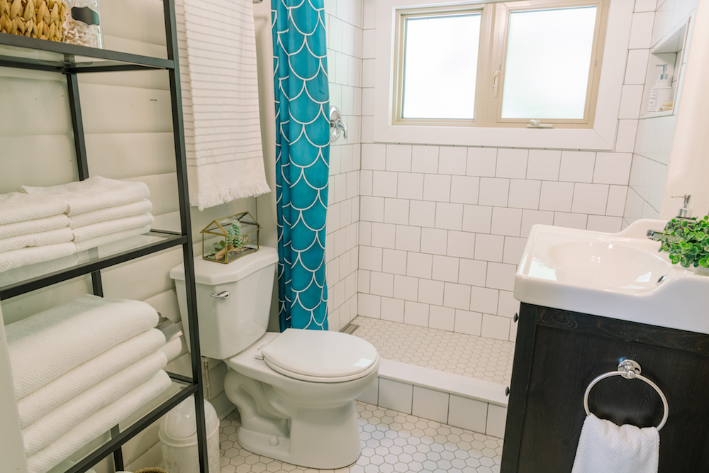 white bathroom with shower and blue shower curtain