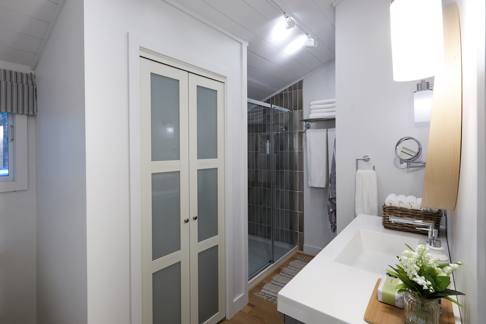 modern white bathroom with tiled shower and laundry closet