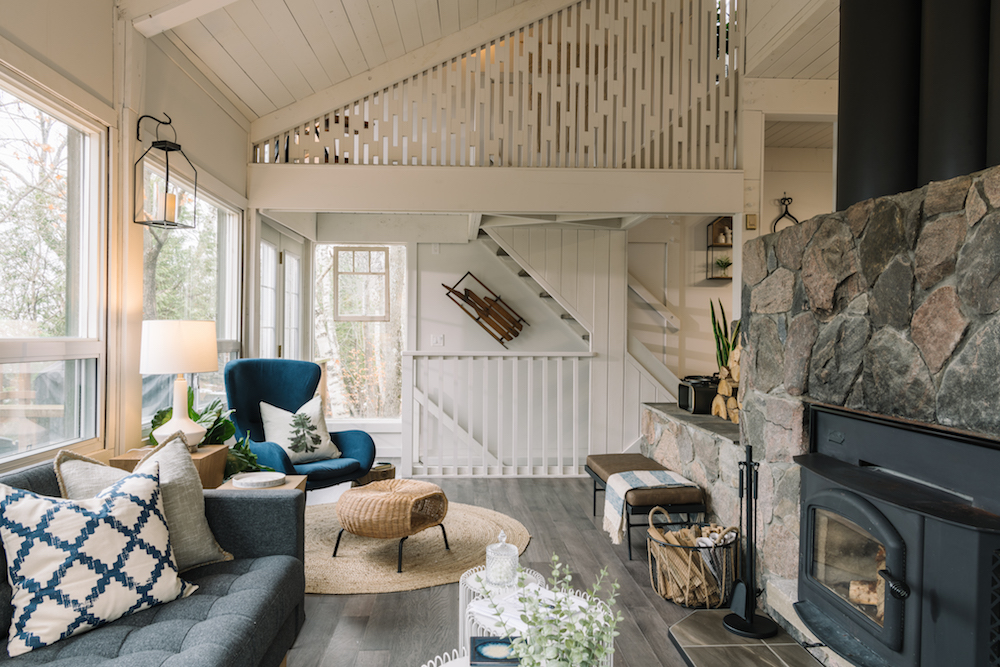 chic white chalet living room with stone fireplace and blue and grey accents