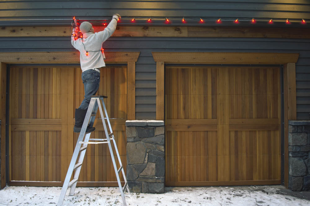 Man hanging holiday lights outdoors