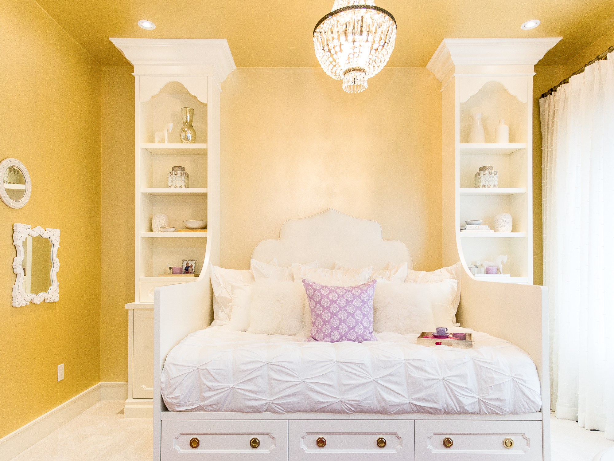 Little girl's bedroom with custom built-in shelves around bed