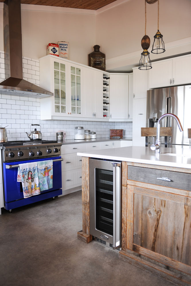 kitchen with blue oven and wood base island with wine fridge