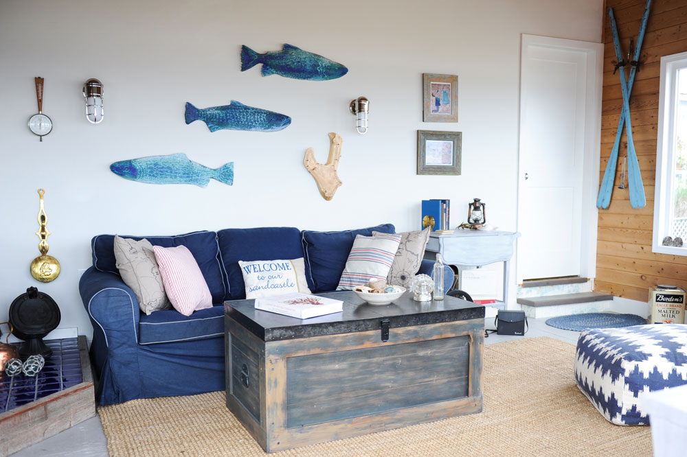 blue sofa under three blue fish on white wall