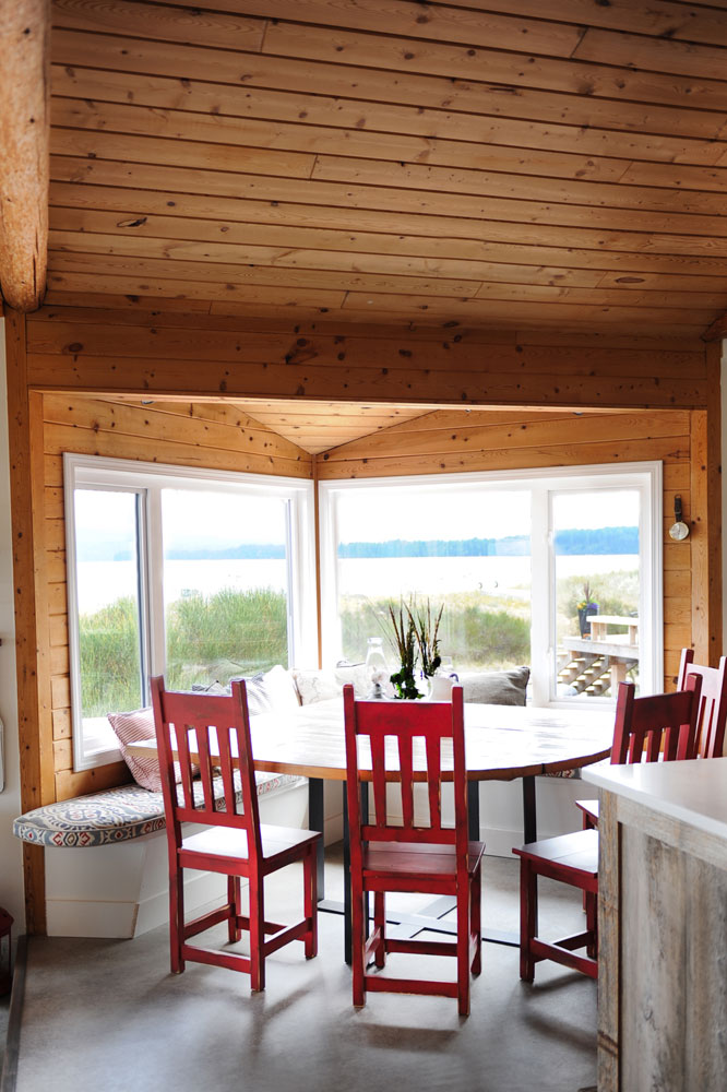 wood ceiling above kitchen table with red chairs and view
