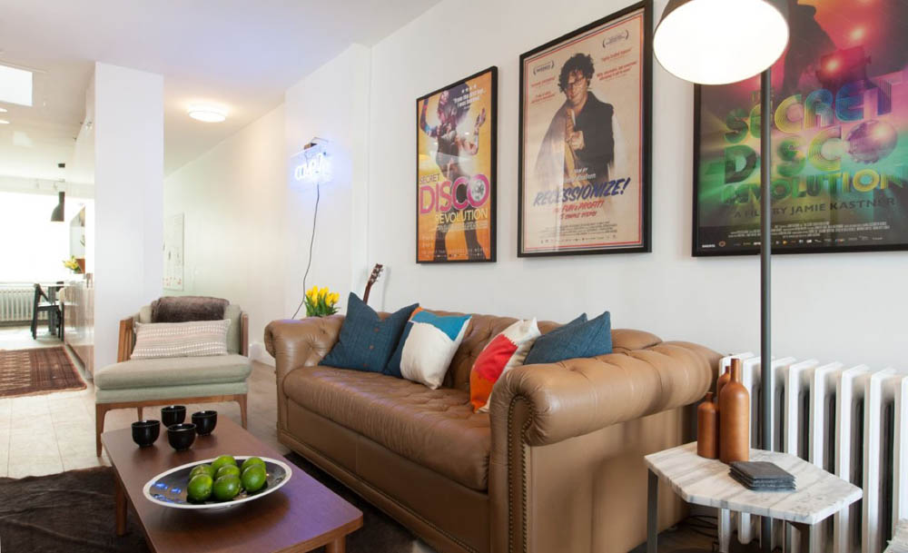 Living room with brown leather couch and music posters