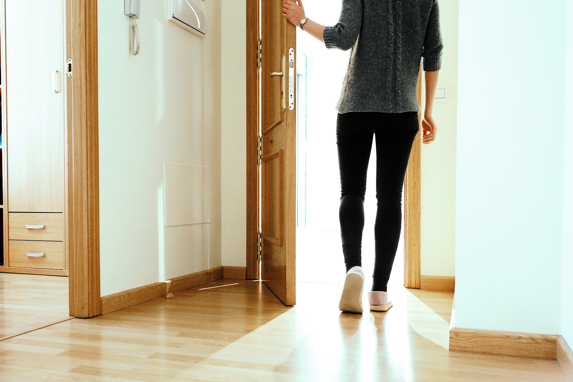 Woman walking through apartment door