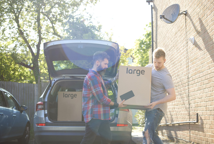 Couple unloading moving boxes from car