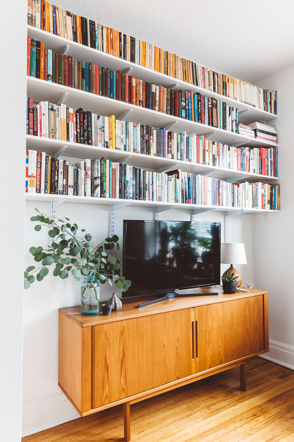 Shelves lined with books above TV
