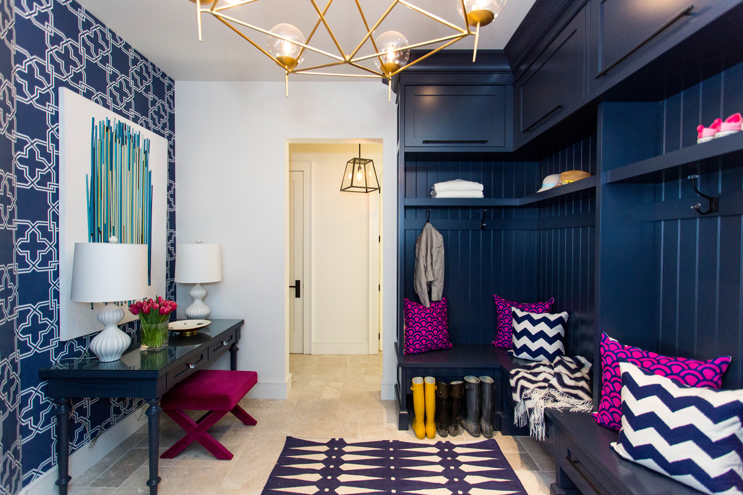 Navy blue mudroom with pink accents and limestone floor
