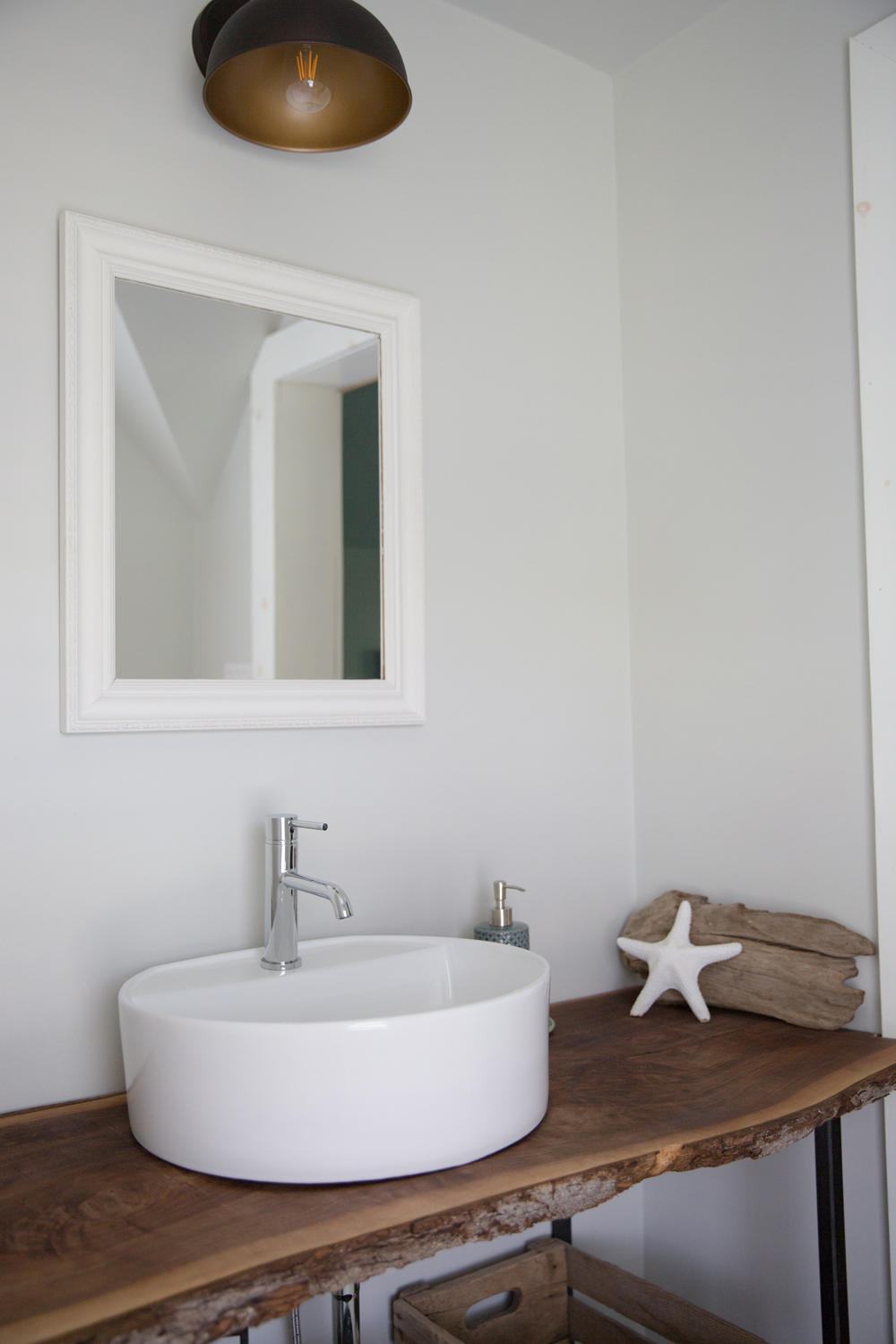 Rustic wood bathroom vanity with white cylinder sink