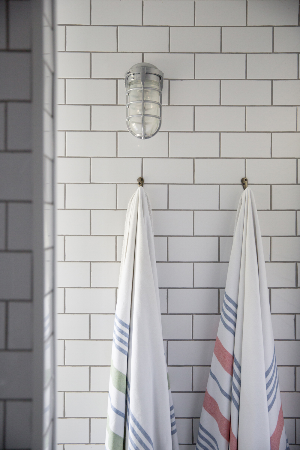 Turkish bath towels hanging against white subway tile bathroom wall