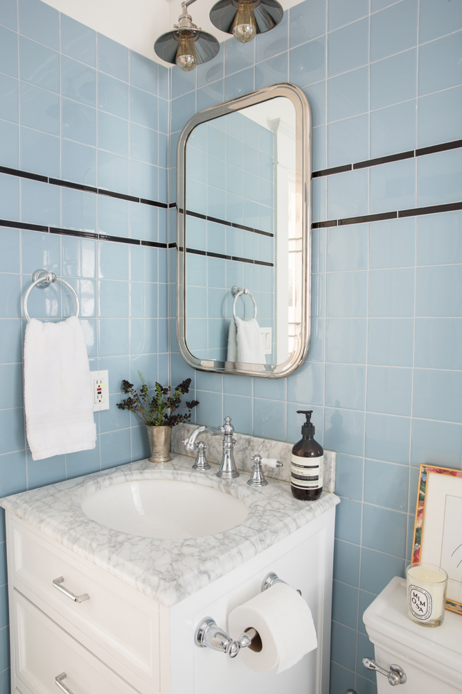 Small bathroom with blue tile and white vanity