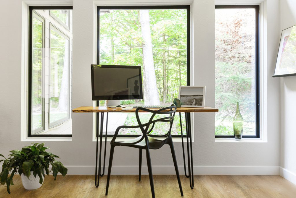 Desk in front of large window looking onto nature