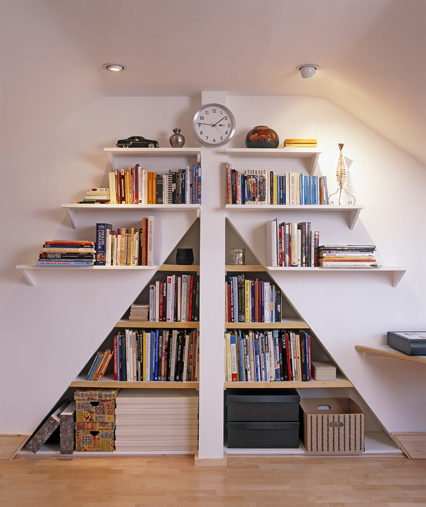 a triangular bookcase built into wall