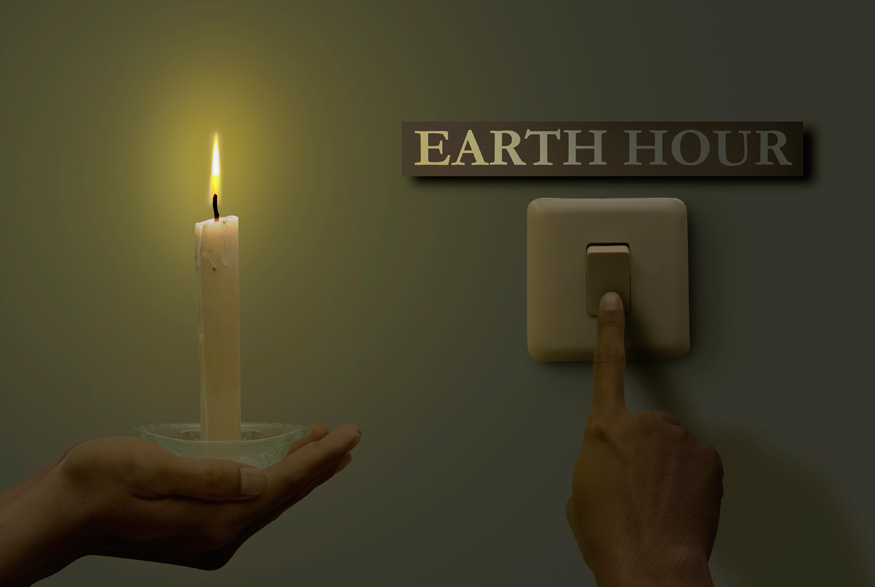 Switch on wall, candle and Earth Hour sign