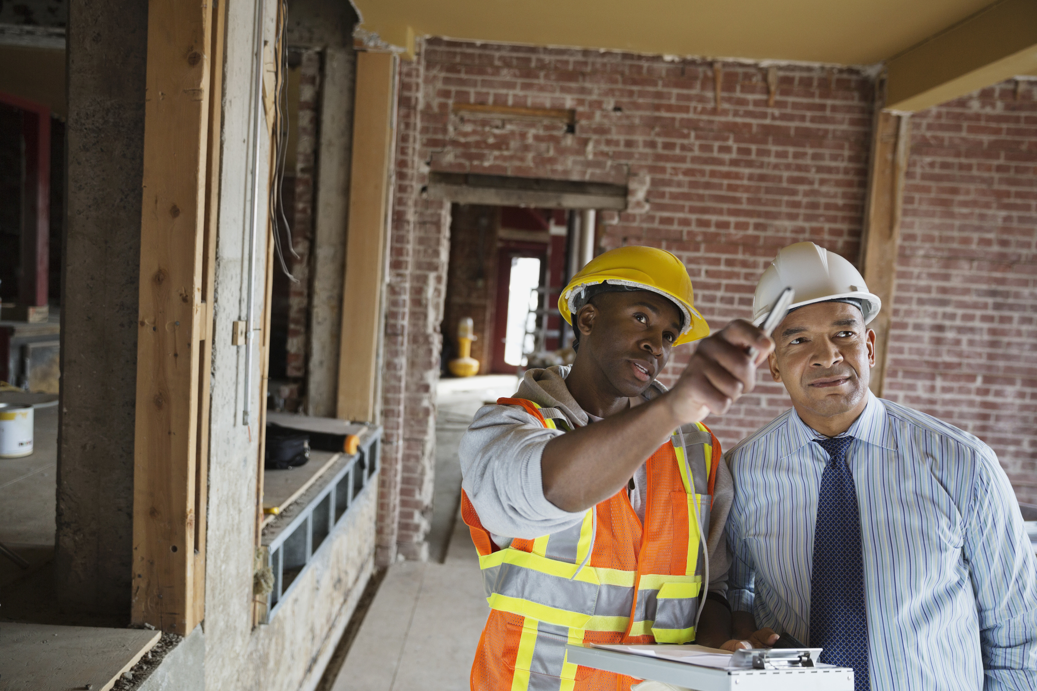 Tradesman and architect discussing work order at construction site
