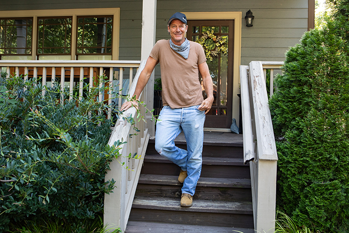 Ty Pennington standing halfway down an outdoor staircase