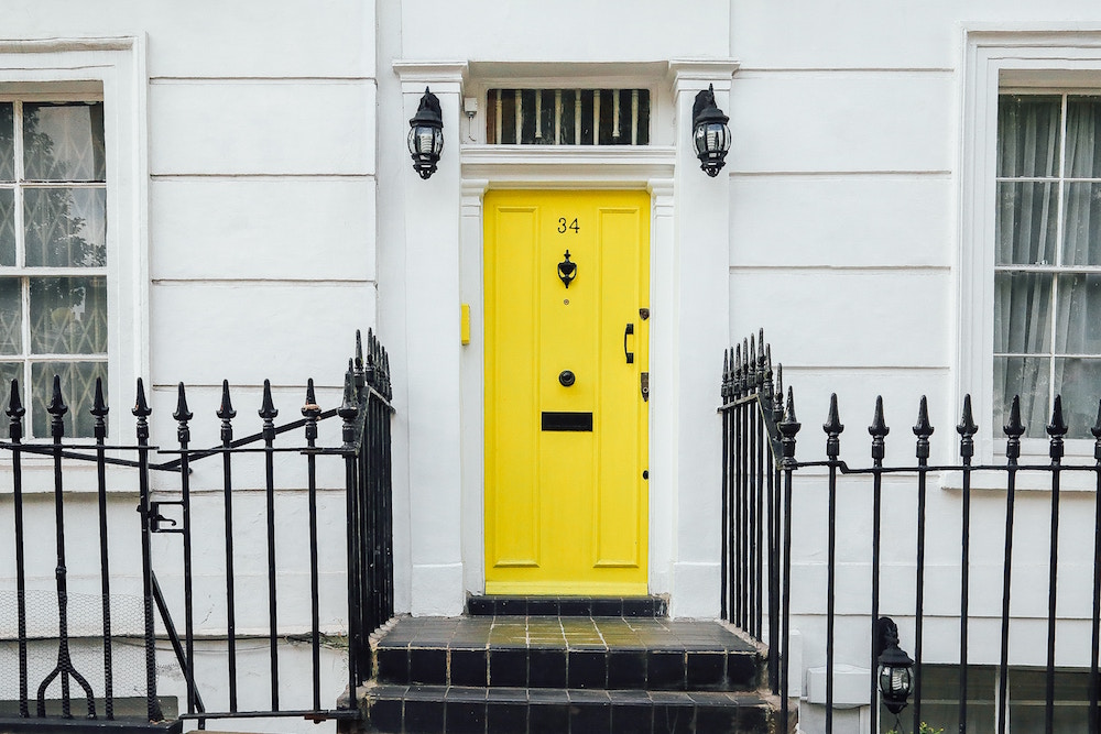 yellow front door on white house