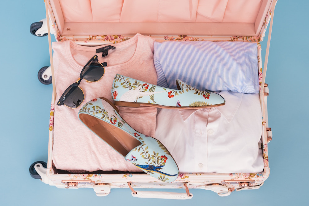 open floral suitcase on blue background