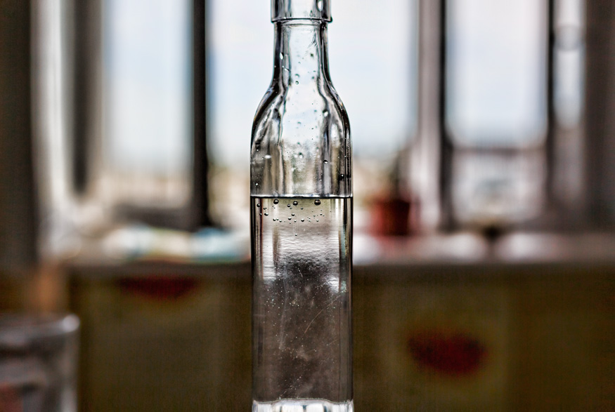 Bottle of vinegar in front of a window
