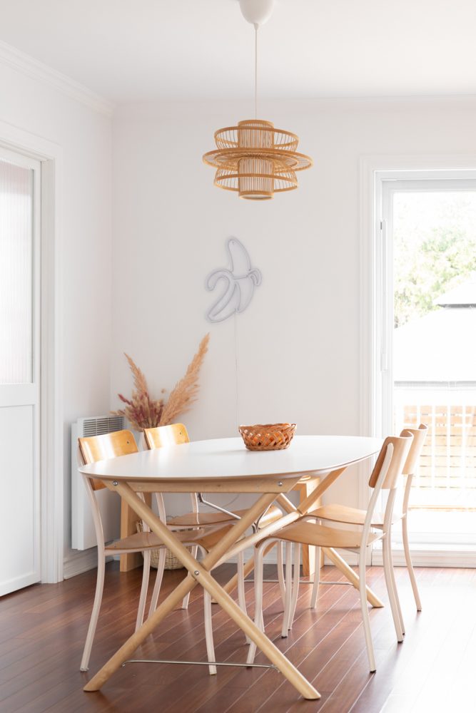 white dining room with woven light fixture and yellow chairs