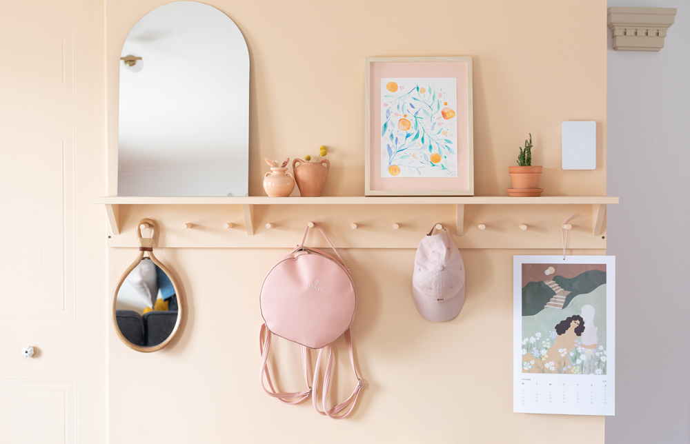 peach entryway with hooks, shelf and art
