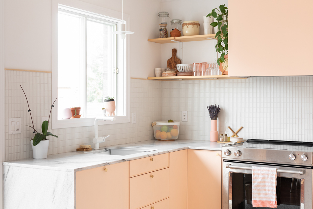 pink-and-white kitchen with open shelves and window