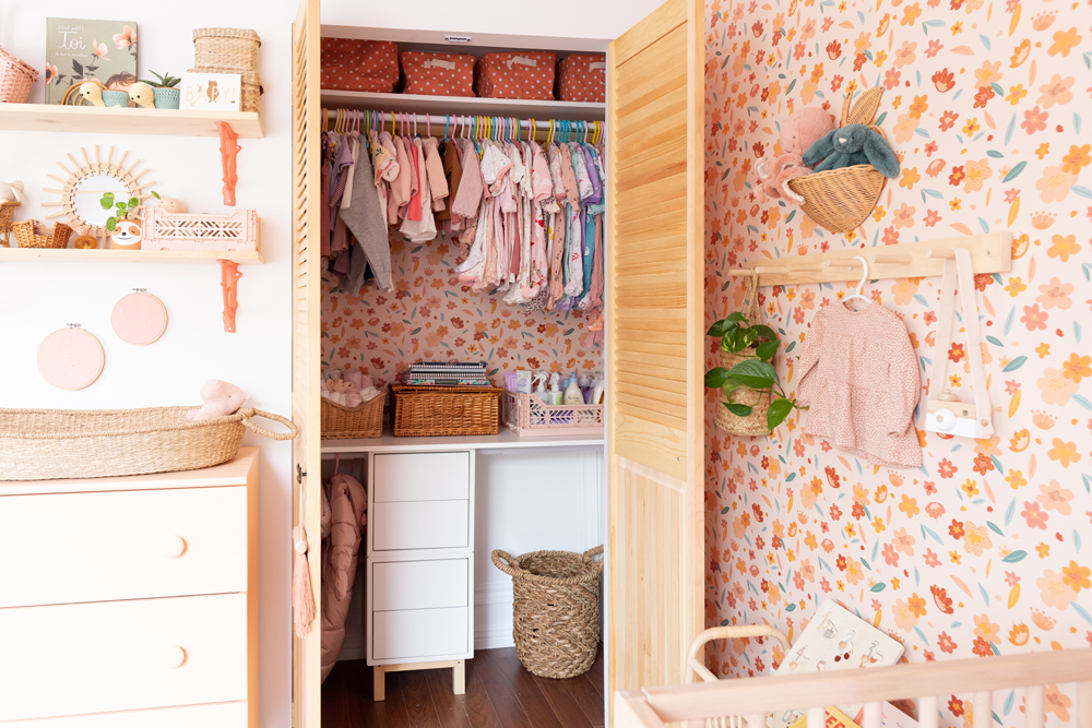 pink nursery with floral wallpaper and organized open closet