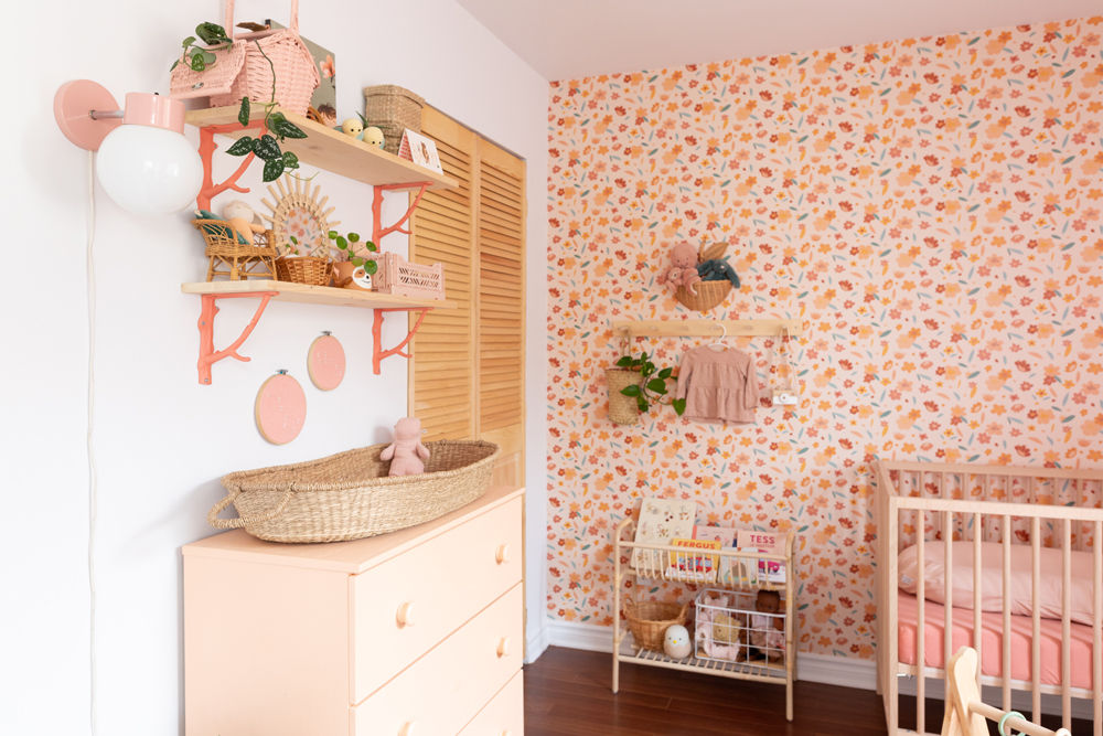 pink nursery with floral wallpaper and shelves
