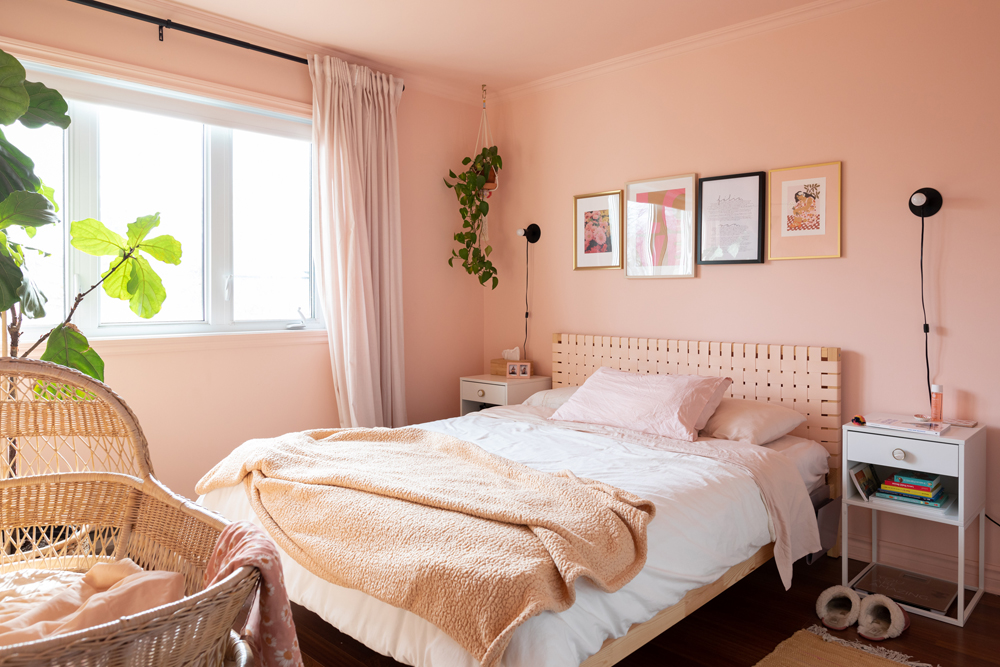 pink bedroom with mis-matched frames over bed