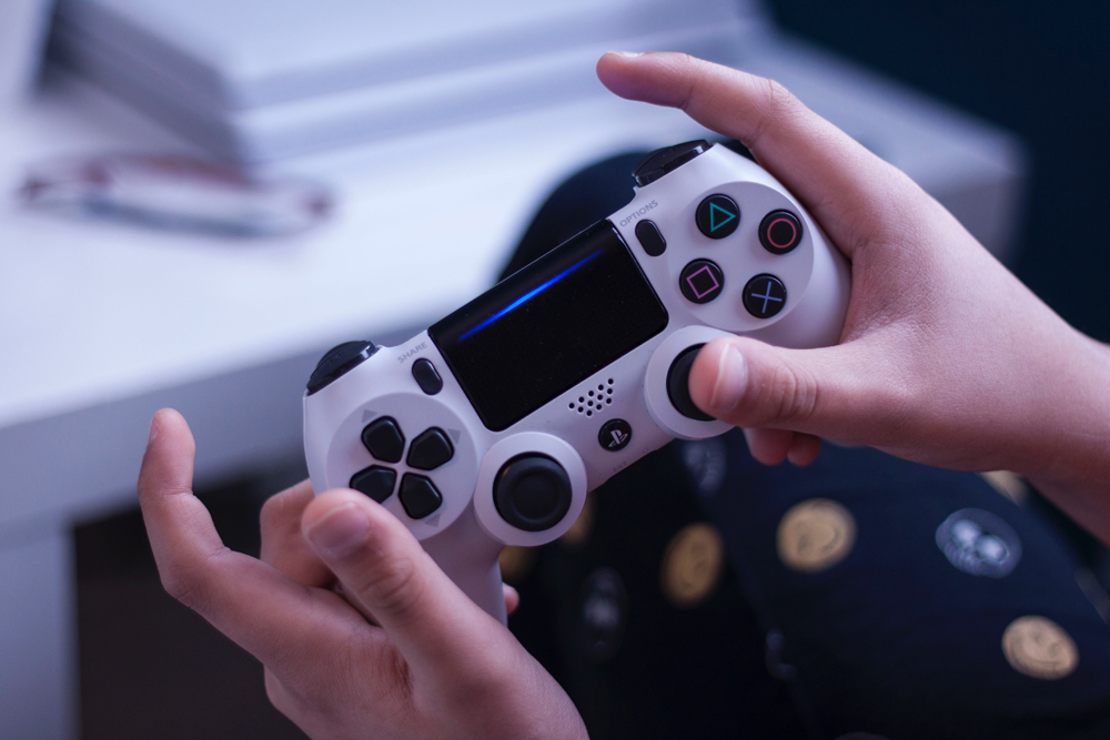 The hands of a preteen holding a video game controller