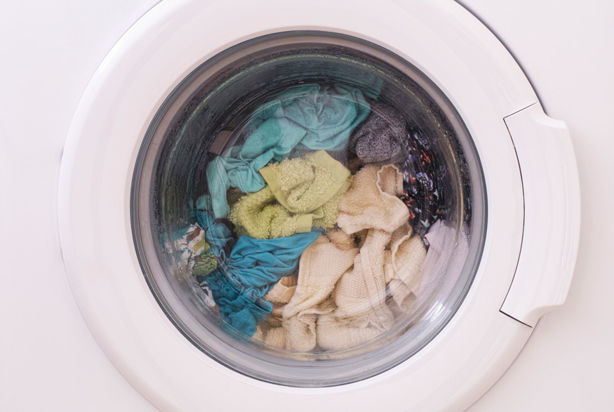 A washing machine filled with multi-coloured towels