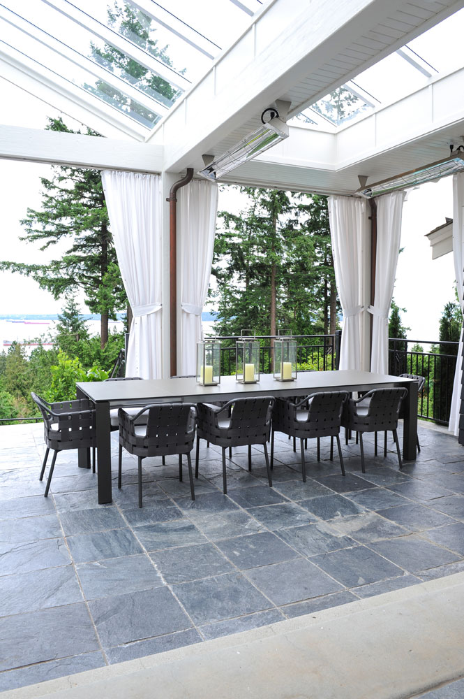 outdoor room with white curtains and long grey dining table with 10 chairs
