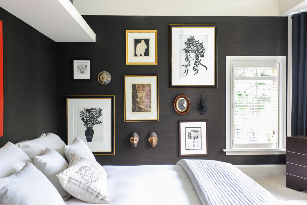white bed in grey wallpaper room with framed art and objects on one wall