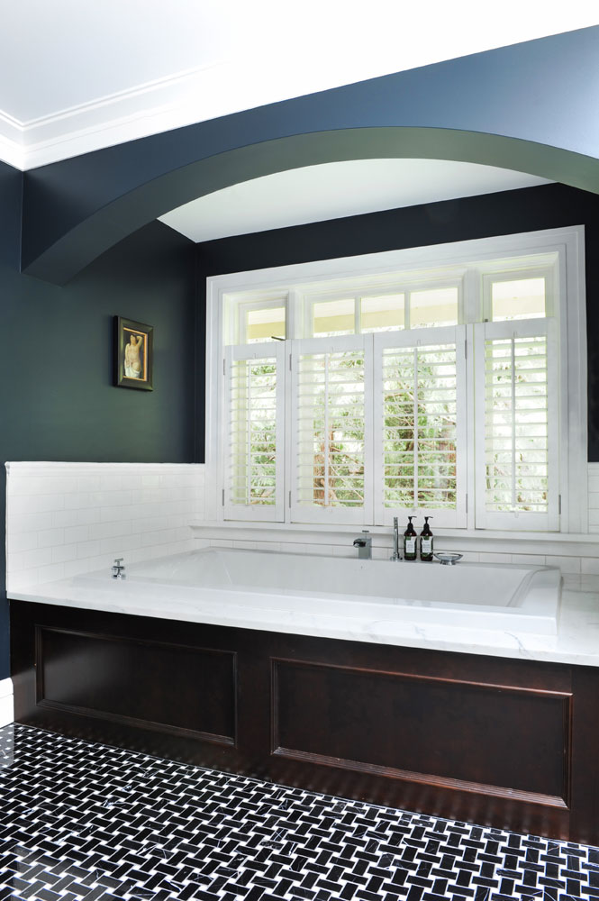 wood-panelled tub beneath white shuttered window