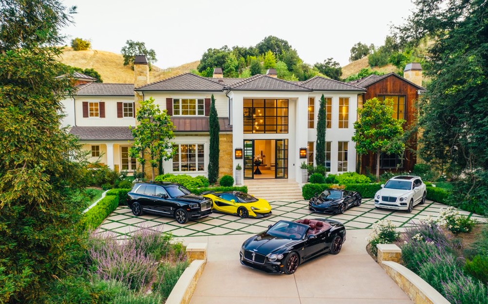 Exterior of mansion with sports cars parked outside