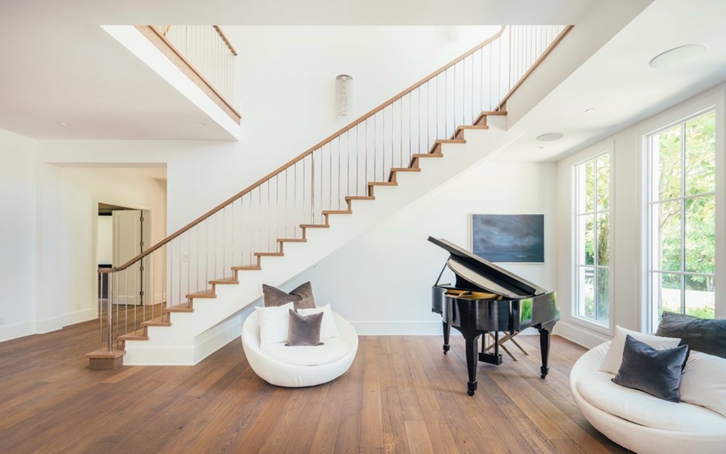 Wood-floored room with piano and staircase