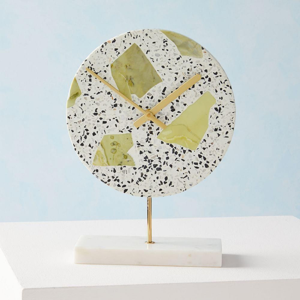 speckled clock with green details on white table