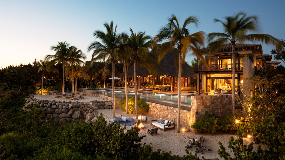 An exterior shot of Casa Koko right by the beach and surrounded by palm trees